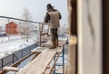 A worker makes mounting a wall on a house