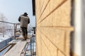 A worker makes mounting a wall on a house