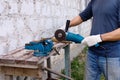 Worker makes repairs  with electric tools  hammer and  pliers in backyard of house in outdoor Royalty Free Stock Photo