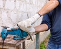 Worker makes repairs  with electric tools  hammer and  pliers in backyard of house in outdoor Royalty Free Stock Photo