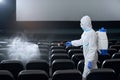 Worker making disinfect in cinema hall for visitors.