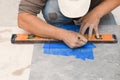 Worker making holes for bathroom water pipes in tile indoors, closeup