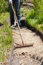 Worker making a walk path in garden decorated with wooden stumps. Royalty Free Stock Photo