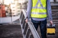 Worker man carrying aluminium ladder and tool box Royalty Free Stock Photo