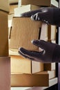 A worker man hands hold cardboard boxes on the shelves of a fully stocked warehouse. Warehouse overflowing with boxes of goods and Royalty Free Stock Photo