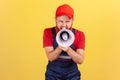 Worker man holding megaphone near mouth loudly speaking, screaming, making announcement. Royalty Free Stock Photo