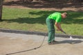 Worker man in uniform washes street or park sidewalk. Municipal service of city cleaning process. Guy uses water spray equipment