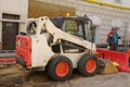 Worker man and universal Bobcat loader at the repair of city communications Royalty Free Stock Photo