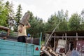 Worker man unload tree logs firewood from trailer Royalty Free Stock Photo