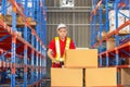 Worker man using hand pallet jack unloading package boxes at factory warehouse, Cheerful warehouse worker checking inventory and Royalty Free Stock Photo