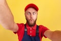 Worker man with wearing blue uniform taking selfie, looking at camera with crossed eyes POV. Royalty Free Stock Photo