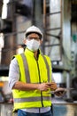 Worker man wearing face mask prevent covid-19 virus and protective hard hat. Engineer Operating lathe Machinery Royalty Free Stock Photo