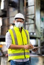 Worker man wearing face mask prevent covid-19 virus and protective hard hat. Engineer Operating lathe Machinery Royalty Free Stock Photo