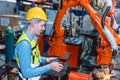 Worker man working with robot arm automate welding machine in modern metal factory. Engineer program robotic in heavy industry Royalty Free Stock Photo