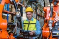 Worker man working with robot arm automate welding machine in modern metal factory. Engineer program robotic in heavy industry