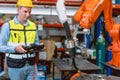 Worker man working with robot arm automate welding machine in modern metal factory. Engineer program robotic in heavy industry Royalty Free Stock Photo