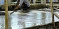 Worker man working wet cement floor by use trowel hands spreading poured concrete for strong after dry. professional decoration me Royalty Free Stock Photo