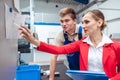 Worker and manager on factory floor discussing product specifications Royalty Free Stock Photo