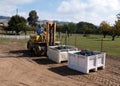 Worker manning forklift with grapes at winery