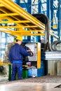 Worker in manufacturing plant at machine control panel