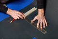 A worker marks out a sheet of roofing iron with a pencil and a ruler Royalty Free Stock Photo
