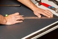 A worker marks out a sheet of roofing iron with a pencil and a ruler Royalty Free Stock Photo