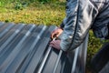 A worker marks a piece of metal sheet on grass background Royalty Free Stock Photo