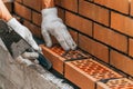 Worker or mason hands laying bricks close up. Bricklayer works at brick row. Brickwork on construction site Royalty Free Stock Photo