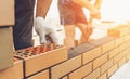 Worker or mason hands laying bricks close up. Bricklayer works at brick row. Brickwork on construction site Royalty Free Stock Photo