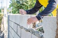 Worker masonry are building walls with cement blocks and mortar