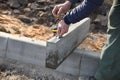 A worker measures a concrete block of pavement with a ruler ,the construction of a ring road.