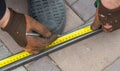 A worker measures metal at a construction site.