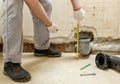 A worker is measuring the sewage drain pipe Royalty Free Stock Photo