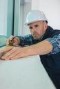 Worker measuring window at construction site Royalty Free Stock Photo