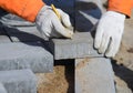 A worker in mittens makes markings on the paving slabs. Royalty Free Stock Photo