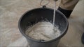 Worker mixing plaster in a bucket for alignment and putty walls of the apartment using an electric drill, close-up. Worker mixes Royalty Free Stock Photo