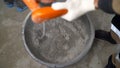 The worker mixes the mortar in a bucket. Builders use large bucket grout mixers