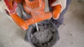 The worker mixes the mortar. Wet Concrete or motrar mixing texture. Gray mortar, concrete surface. The solution is stirred,