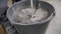 The worker mixes the mortar. Wet Concrete or motrar mixing texture. Gray mortar, concrete surface. The solution is stirred,