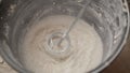 Mix the solution in a bucket using a construction mixer. Worker mixing plaster in a bucket for alignment and putty walls of the Royalty Free Stock Photo