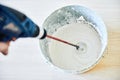 Worker mixing plaster in bucket using an electric drill Royalty Free Stock Photo