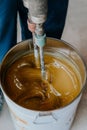 Worker mixing yellow epoxy resin with the mixer Royalty Free Stock Photo