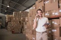 Worker with mobile phone and digital tablet in warehouse Royalty Free Stock Photo