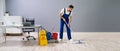 Worker Mopping Floor With Wet Floor Caution Sign Royalty Free Stock Photo