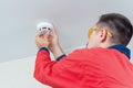 Worker mounting fire alarm or smoke detector on the ceiling Royalty Free Stock Photo