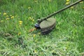 Worker mowing grass with a trimming machine. Royalty Free Stock Photo