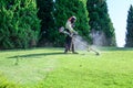 Worker mowing lawn in garden