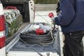 Worker near car with power extander electrical plug for construction work with red sockets in his hands Royalty Free Stock Photo