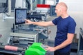 Worker next to the printing machine inputs the data by pressing the touch screen.