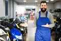 Worker offers a look at the range of motorcycle models Royalty Free Stock Photo